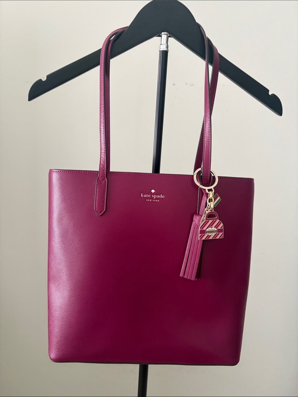 Kate Spade  Oxblood Leather Tote with Tassel 
and charm  13.5” L X 11.5” W.